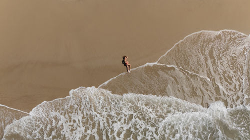 Rear view of man standing on rock