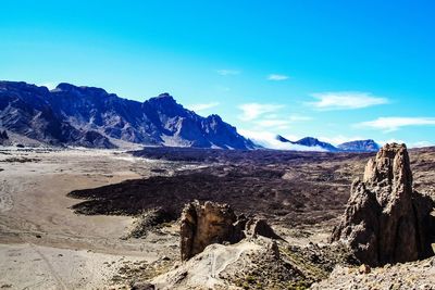 Scenic view of desert against blue sky