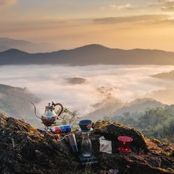 People on mountains against sky during sunset