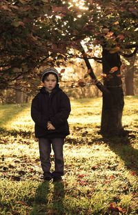 Full length of boy standing on field during autumn