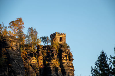 Low angle view of trees and building against sky