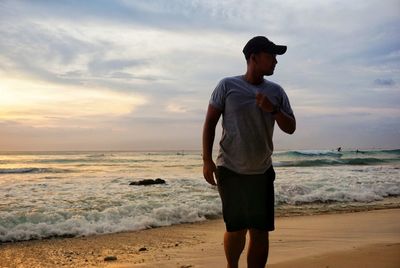 Man walking at beach against sky