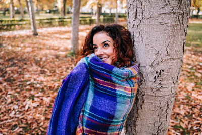 Portrait of a smiling young woman in autumn tree