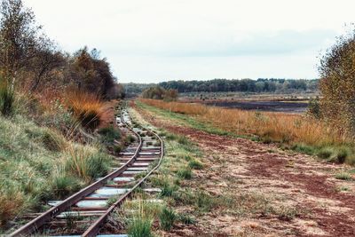 View of railroad tracks on field against sky