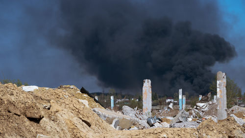 Smoke emitting from rocks against sky