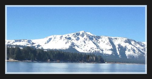 Scenic view of snowcapped mountains against blue sky