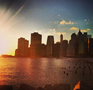 Skyscrapers in city at sunset