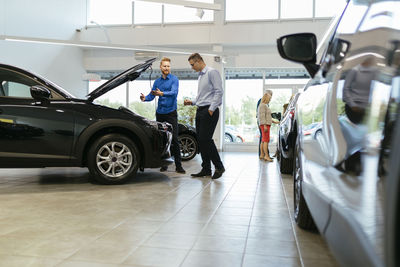 Salesman advising customer in car dealership