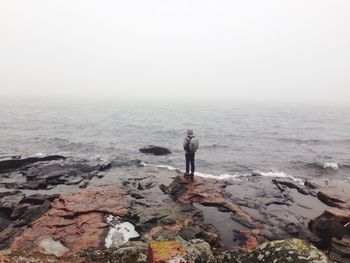 Man standing on beach against sky