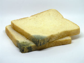 Close-up of bread in plate against white background