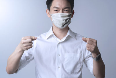 Portrait of young man standing against white background