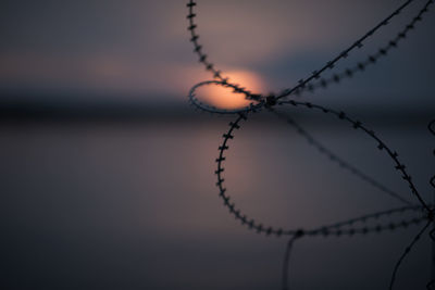 Close-up of chain against sky at sunset