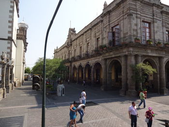 People on street amidst buildings in city