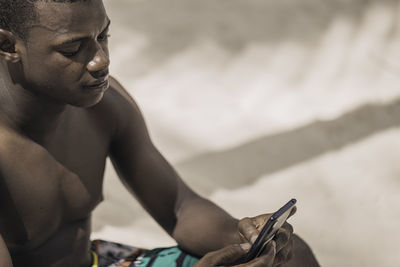 Low section of man exercising at beach