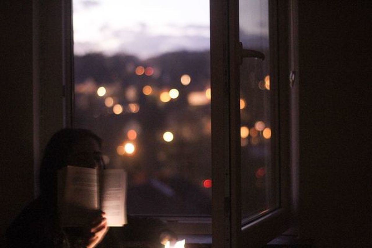 PORTRAIT OF PERSON PHOTOGRAPHING ILLUMINATED WINDOW