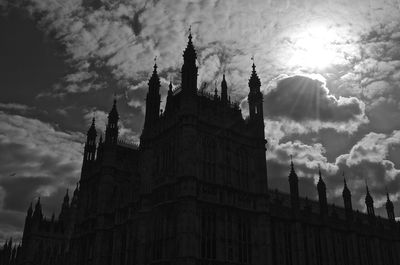 Palace of westminster against cloudy sky on sunny day