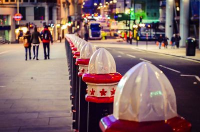 Close-up of bollards by road at night