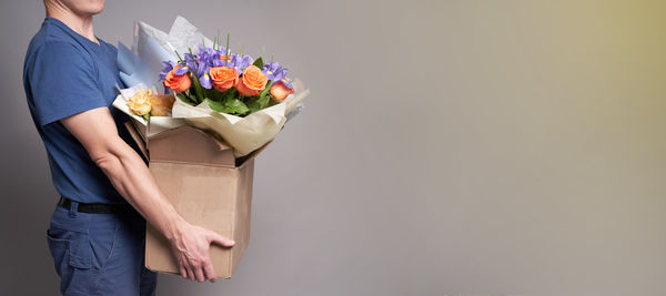 Midsection of bride holding bouquet