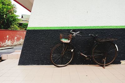 Bicycle parked against wall in city