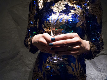 Midsection of woman holding drinking glass