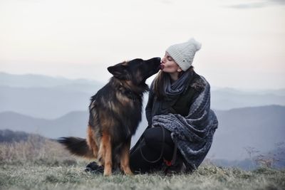Woman with dog on mountain during winter