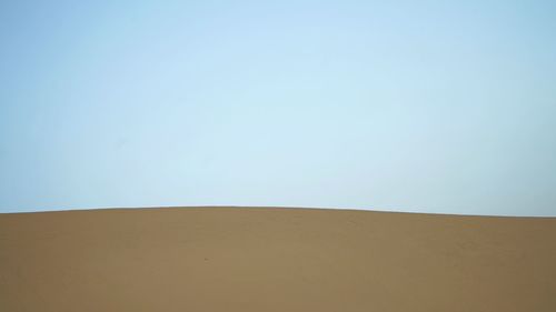 Scenic view of desert against clear blue sky