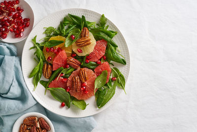 Fruits citrus salad with nuts, green lettuce leaves. copy space. balanced food. spinach