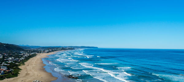 View of waves, beach, and coastal town