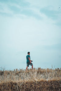 Man standing on field against sky