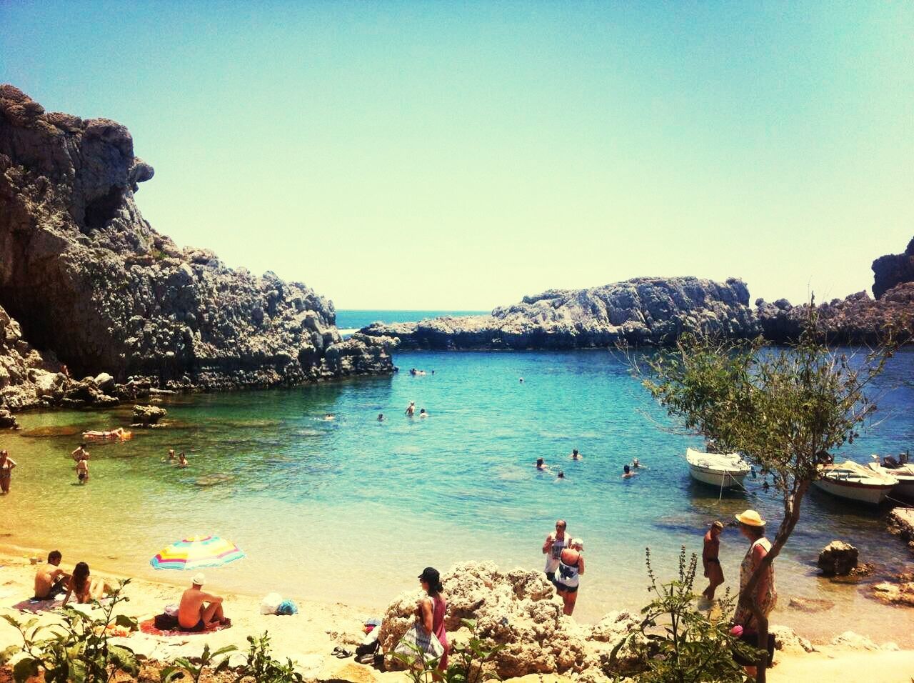 water, clear sky, sea, leisure activity, lifestyles, copy space, beach, beauty in nature, scenics, blue, men, vacations, large group of people, nature, tranquil scene, tranquility, shore, person, rock - object