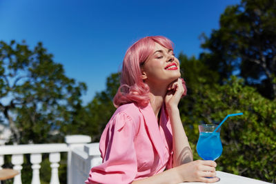 Young woman drinking cocktail on terrace