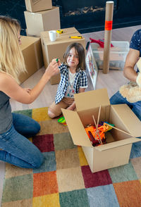 High angle view of parents with son unpacking boxes at home