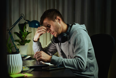 Young woman using mobile phone while sitting at home