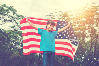 Girl holding american flag on field