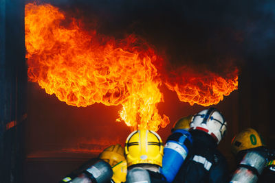 Rear view of firefighters extinguishing fire