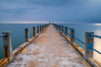 Wooden pier on sea against sky