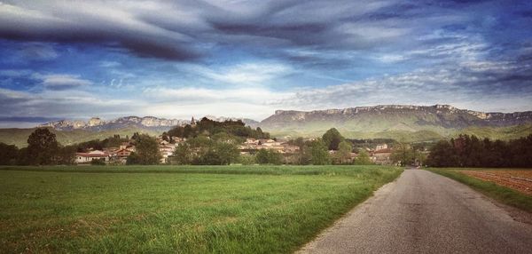 Scenic view of grassy field against cloudy sky