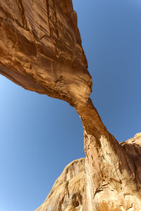 Low angle view of rock formation against clear blue sky