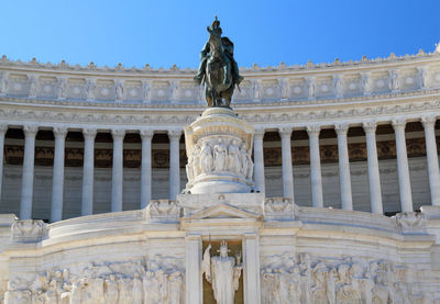 Low angle view of altare della patria against clear blue sky in city