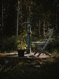 Abandoned chair on field in forest