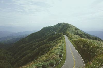 Country road against cloudy sky