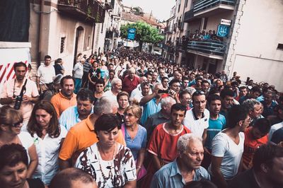 People on street against buildings in city