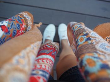 Low section of woman wearing white shoes standing on footpath