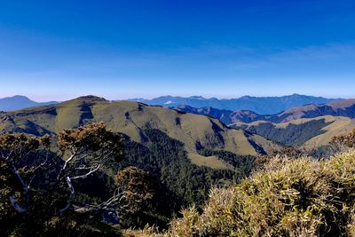 Scenic view of mountains against blue sky