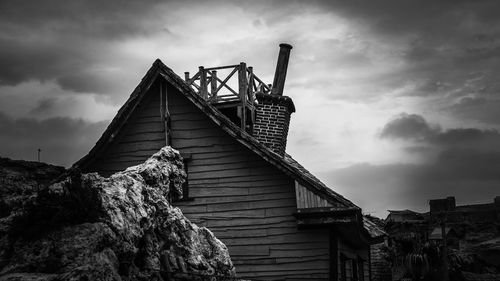 Low angle view of abandoned house against sky