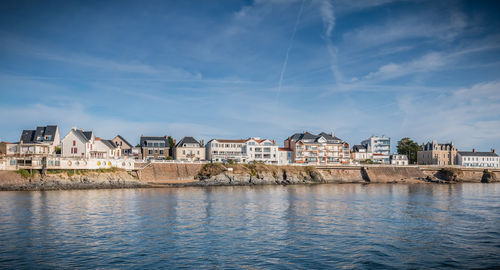 River by buildings in town against sky