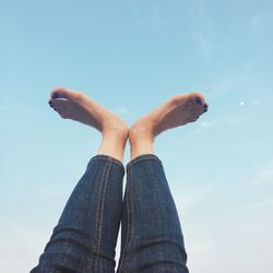 Low section of person against blue sky