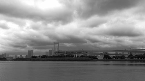 Bridge over river against sky in city