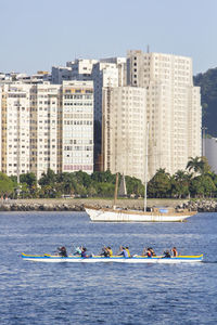 Boats in sea against buildings in city