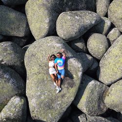 Full length of happy friends standing on rocks